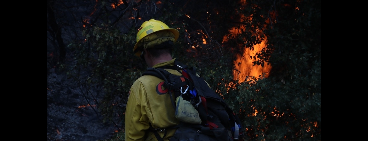 Photo depicts a firefighter and flames from the 2020 Apple fire in California.
